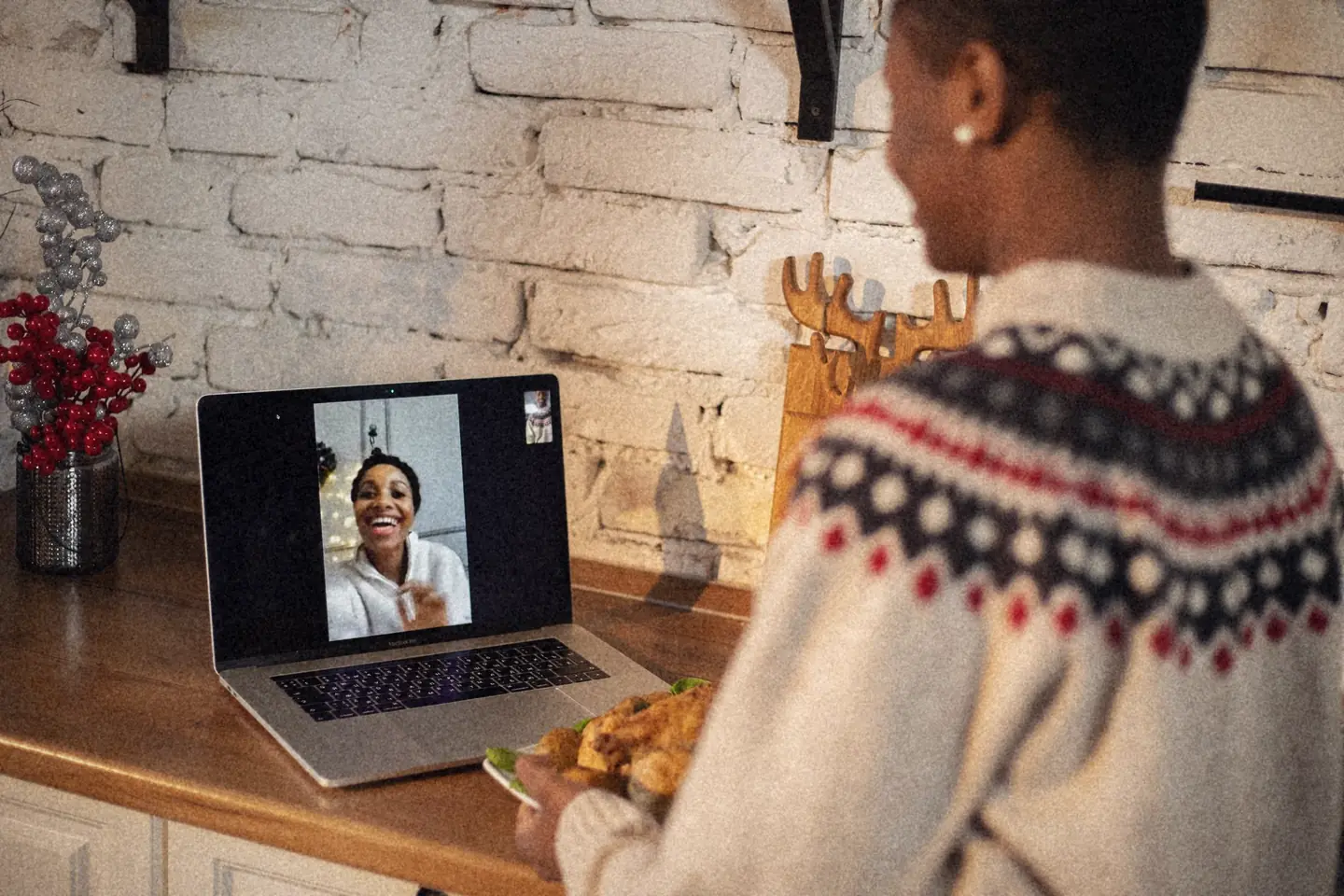 A woman waving on a laptop video call
