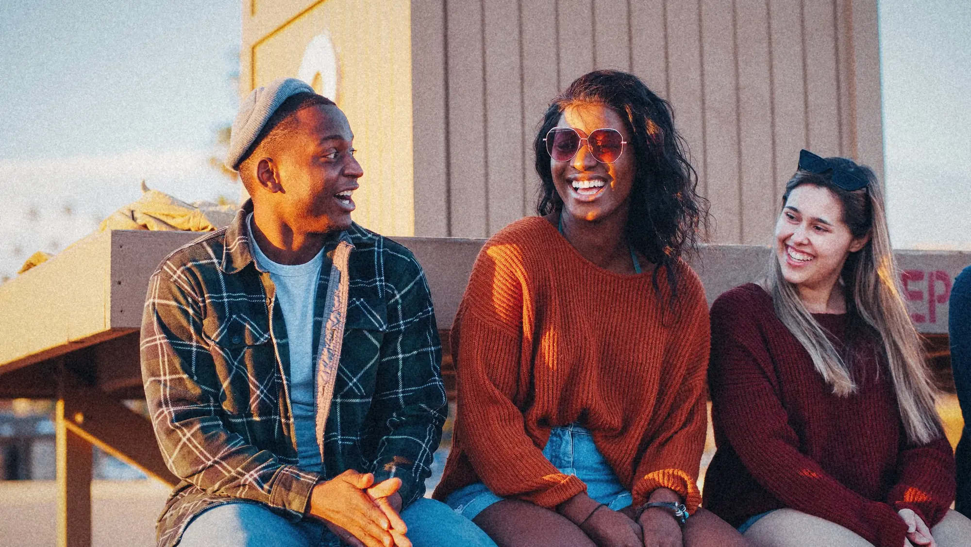 Three friends sitting together in the sun
