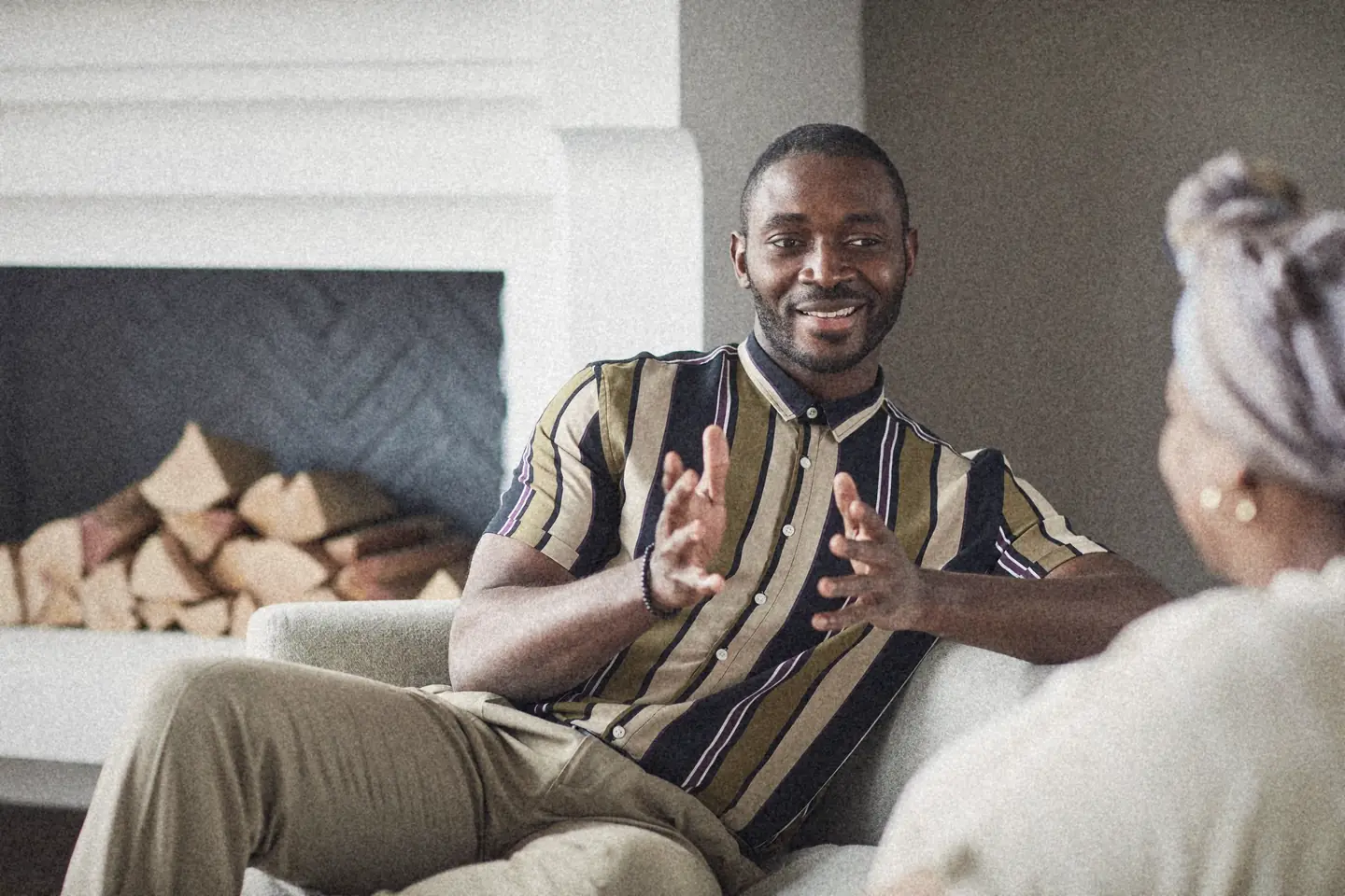 A man explaining something with a big smile on a sofa